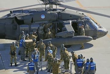 米軍ヘリで運び込まれた支援物資を受け取る自衛隊員ら＝17日、能登空港