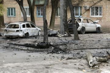 23日、ウクライナ・キーウの集合住宅の一角で、爆発により大破した車や電柱（共同）
