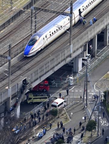 さいたま市中央区で停車した新幹線。降車した乗客らは線路脇の非常階段（左）から地上に向かった＝23日午後1時12分（共同通信社ヘリから）
