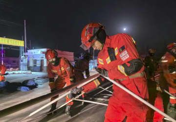 地震の被災地でテントを組み立てる救助隊員ら＝23日、中国新疆ウイグル自治区アクス地区ウシュトゥルファン県（新華社＝共同）