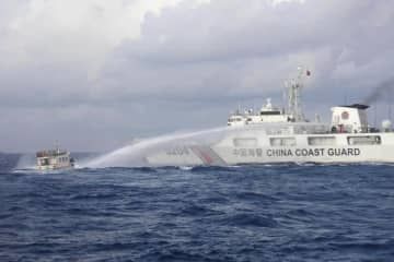 南シナ海のアユンギン礁付近でフィリピン当局の船に向かって放水砲を発射する中国海警局の船＝2023年12月（フィリピン沿岸警備隊提供、AP＝共同）