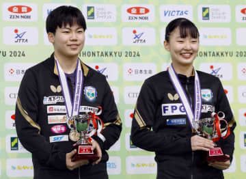 ジュニアの部シングルスで優勝し、トロフィーを手に笑顔を見せる男子の松島輝空（左）と女子の張本美和＝東京体育館