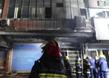 24日、中国江西省新余市の火災現場で活動する消防士ら（AP＝共同）