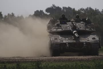 23日、パレスチナ自治区ガザで、戦車に乗ったイスラエル軍兵士（AP＝共同）