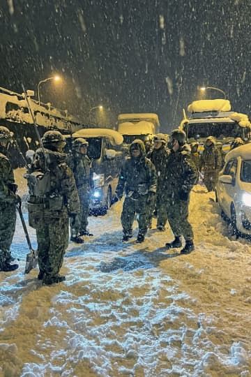 名神高速道路関ケ原インターチェンジ付近で除雪作業をする陸上自衛隊員ら＝25日午前（防衛省提供）