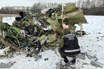 ロシア西部ベルゴロド州で、墜落したロシア軍の大型輸送機イリューシン76の残骸を調べる捜査関係者＝24日（画像の一部が加工されています、タス＝共同）