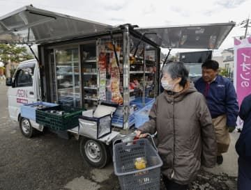 避難所で移動販売車の営業が始まり、買い物をする住民ら＝29日午前、石川県輪島市
