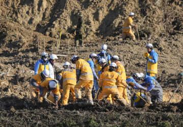 石川県珠洲市仁江町の土砂崩れ現場で、安否不明者の捜索に当たる消防隊員ら＝29日午後