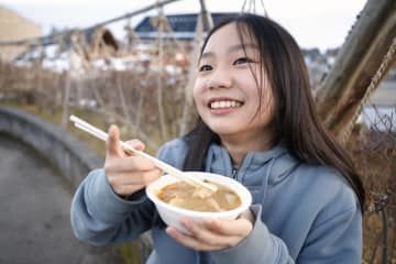 茨城県北茨城市の職員らが用意したあんこう鍋を食べる小学生＝31日午後、石川県珠洲市