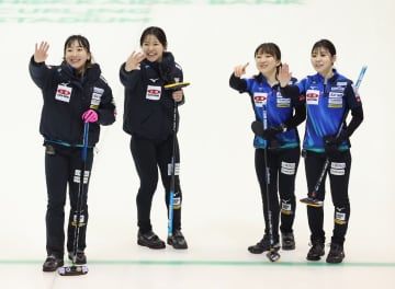 女子1次リーグで北海道銀行に勝利し、笑顔で手を振るロコ・ソラーレの藤沢（左端）ら＝どうぎんカーリングスタジアム（代表撮影）
