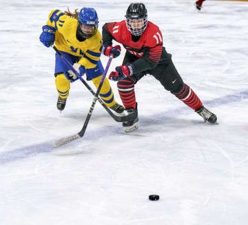 アイスホッケー女子決勝でスウェーデン選手と競り合う沼辺亜澄（右）＝江陵（OIS提供・共同）