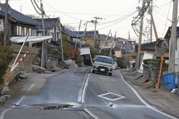 液状化とみられる現象で隆起した石川県内灘町の道路＝1月29日