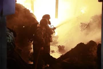 2日、ケニアの首都ナイロビで、ガス爆発による火災の消火活動をする消防士ら（AP＝共同）