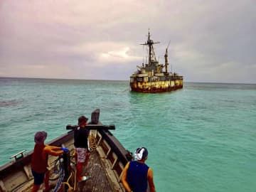 フィリピン軍が2022年6月に公開した、軍拠点となっている南シナ海のアユンギン礁の座礁船（奥）（フィリピン軍提供、共同）