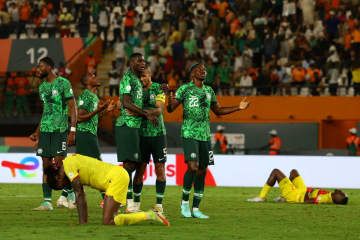 アフリカ選手権準々決勝を終え、勝利を喜ぶナイジェリアの選手たちと倒れ込むアンゴラの選手たち＝2日、アビジャン（ロイター＝共同）