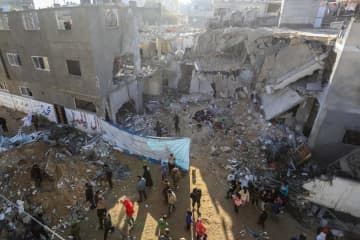 3日、パレスチナ自治区ガザ南部ラファで、イスラエル軍の空爆による家屋への被害を調べる人々（ゲッティ＝共同）