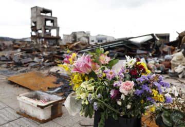 大規模火災でほぼ全域が焼失した「輪島朝市」に手向けられた花＝4日午後、石川県輪島市