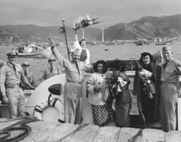 奄美群島が日本に復帰した1953年12月に岩城三郎さんが撮影した、奄美大島の港で笑顔を見せる米軍関係者（奄美博物館蔵、岩城隆二氏提供）