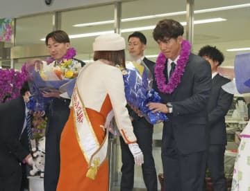 宮崎空港での歓迎セレモニーで花束を受け取る西武・松井監督。左は源田＝5日