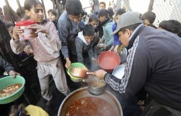 パレスチナ自治区ガザ南部ラファで、食料の配給を受ける子どもたち＝5日（ムハンマドさん提供、共同）