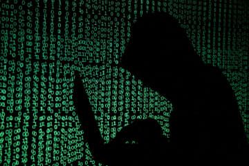 男がコンピューターを操作する、サイバー攻撃のイメージ（ロイター＝共同）