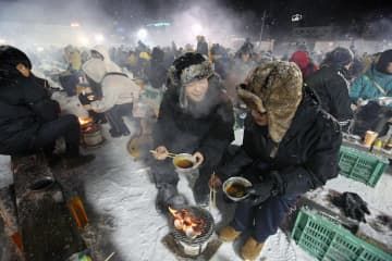 「北見厳寒の焼き肉まつり」を楽しむ人たち＝9日夜、北海道北見市