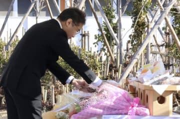 慰霊碑前で行われた供養式で、榊を供える三幸製菓の佐藤元保CEO＝10日午前、新潟県村上市