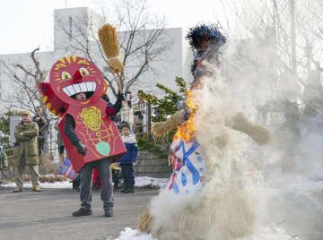 ロシア極東連邦総合大函館校で行われた、わら人形を燃やして春の訪れを祈るロシア式の祝祭「マースレニツァ」。左は春の神「ヤリーロ」＝10日午前、北海道函館市