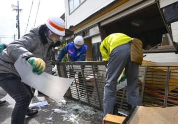 被災した家屋から運び出した災害ごみを分別するボランティア＝10日午後、石川県輪島市