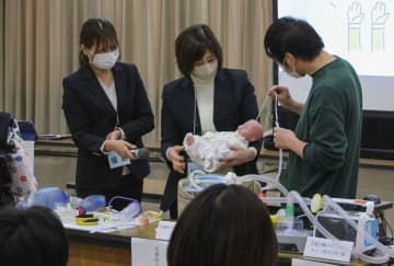 「医療的ケア児」を想定し、たんの吸引を模擬体験するイベント参加者ら＝11日午後、大阪府茨木市