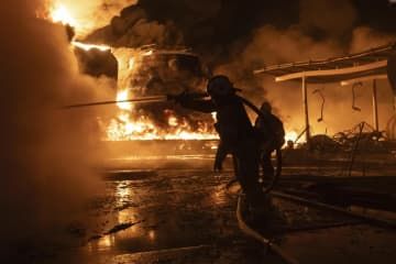 10日、ウクライナ東部ハリコフの住宅街で、ロシアの攻撃による火災に対応する消防士ら（AP＝共同）