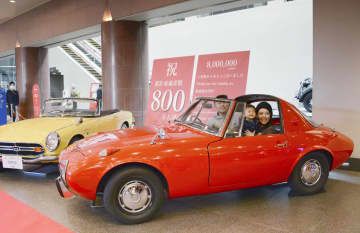 トヨタ博物館の累計800万人目の来館者となり、名車「トヨタスポーツ800」に体験乗車する近藤統靖さん(左)一家=13日午前、愛知県長久手市