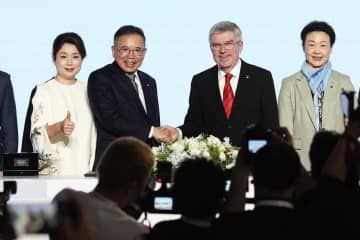 五輪・パラリンピックの最高位スポンサー契約を結び、IOCのバッハ会長(右から2人目)と握手する中国家電大手TCLの李東生会長=20日、北京(共同)