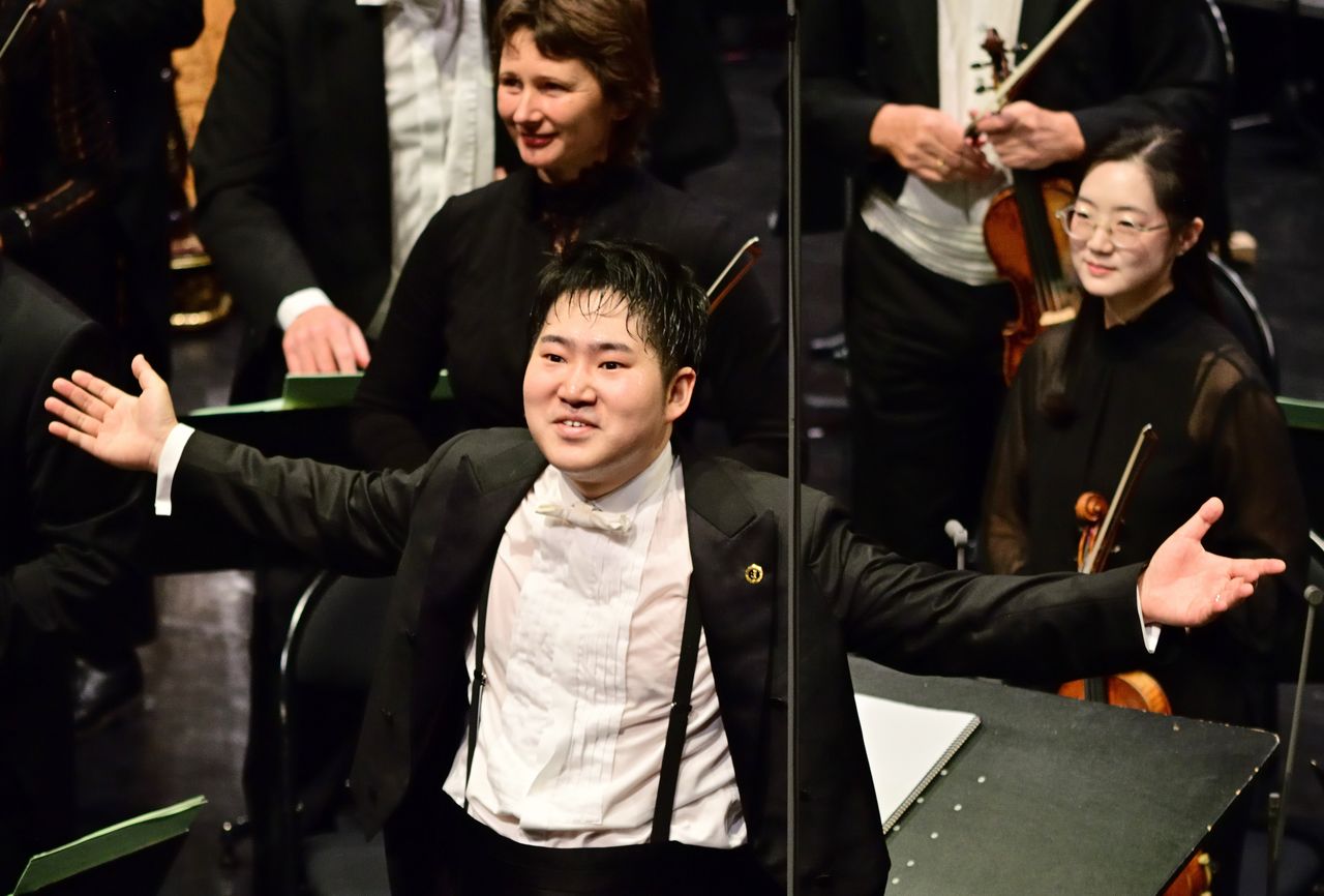 観客の拍手に応える米田覚士さん (フランス東部ブザンソン)(時事)