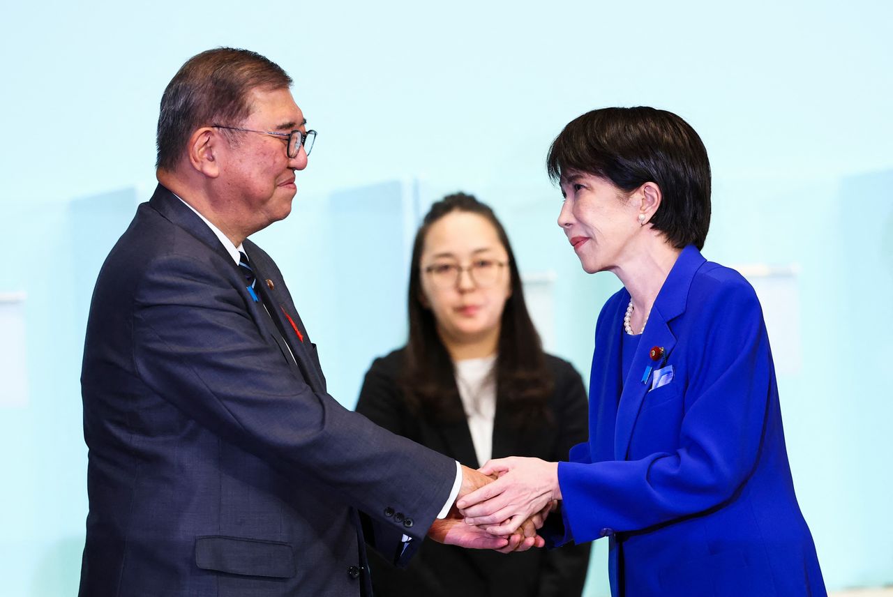 石破氏から高市氏へバトンタッチ(AFP=時事)