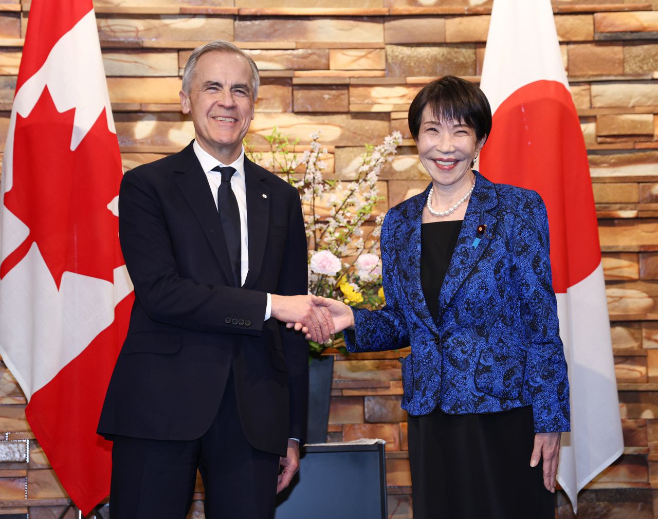 会談を前にカナダのマーク・カーニー首相(左)と握手する高市早苗首相=3月6日、首相官邸 (時事)
