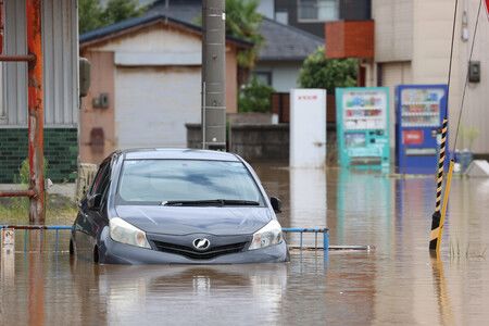 大雨により住宅街で水に漬かった車=30日午後、福井県坂井市