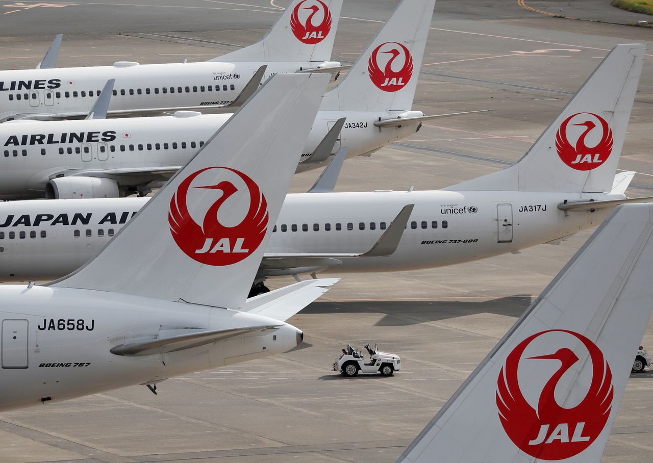 日本航空(JAL)は1日、2021年3月期の連結業績予想(国際会計基準)を下方修正し、純損益が3000億円の赤字となる見通しと発表した。写真は、羽田空港に駐機中の同社の機材。2020年10月30日に撮影。(2021年 ロイター/Issei Kato)