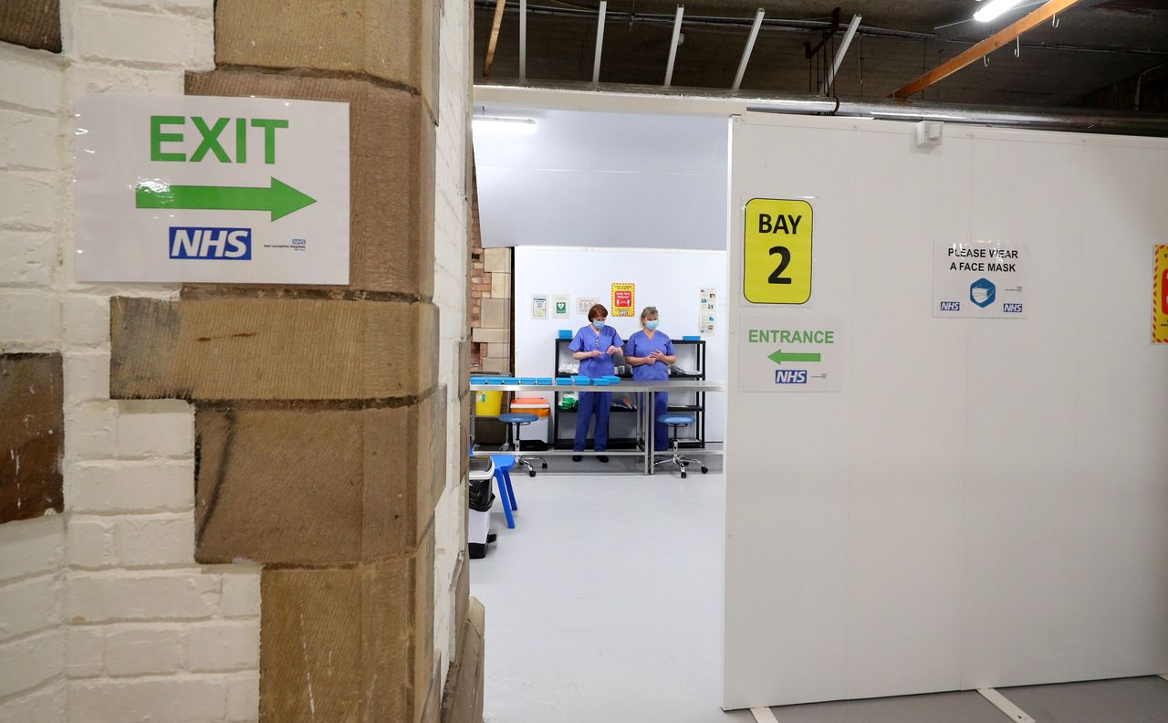 4月23日、 新型コロナウイルスに関する英国の調査で、英アストラゼネカや米ファイザーのワクチンを1回接種した後、全ての年齢層で感染が65%減少したことがわかった。英ブラックバーンの接種会場で1月代表撮影(2021年 ロイター)