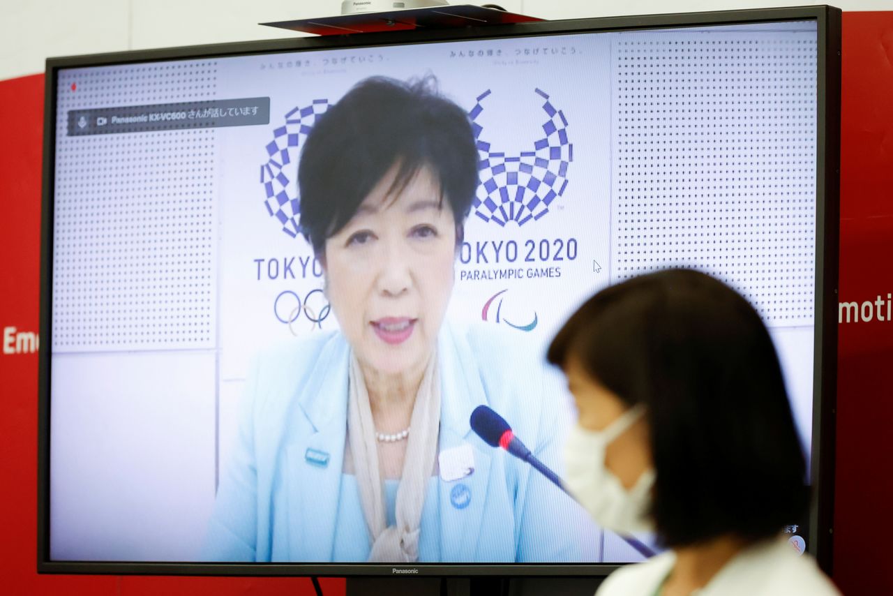 6月22日、東京都は小池百合子知事が過度の疲労で今週いっぱい静養すると報じた。五輪の5者会議にオンラインで参加した小池知事、都内で21日撮影(2021年 ロイター/Rodrigo Reyes Marin/Pool via REUTERS)