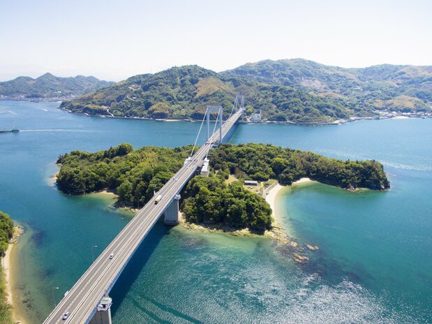 从伯方岛俯瞰伯方大岛大桥。该桥由梁桥和悬索桥组合而成，两种结构在中间的见近岛相接