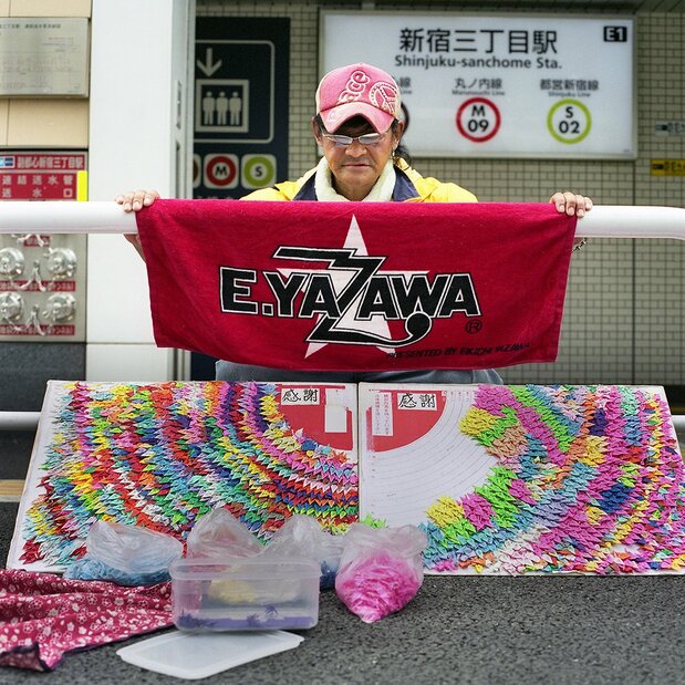 选自《行李》。一名男子张开摇滚歌手矢泽永吉的周边定制毛巾。他的梦想是“自己的小孩能大学毕业”,座右铭是“一寸虫亦有五分魂”(意为“匹夫不可夺其志”——译注)