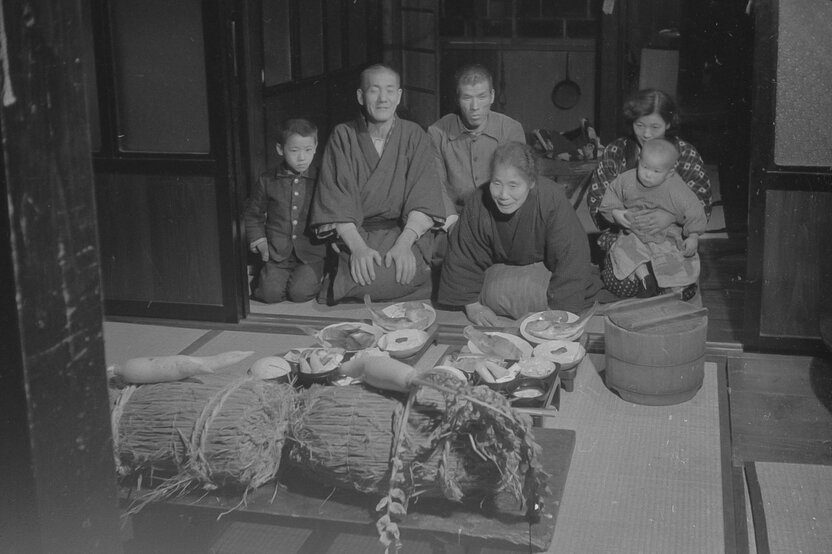 Les offrandes d’aliments et de boissons d’une famille à la divinité des rizières Ta-no-kami, qui est représenté par des ballots de semences de riz et des radis blancs daikon fourchus. (© Haga Hideo)
