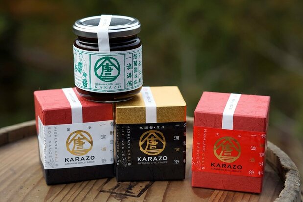 Variaciones de Karazō. Abajo, desde la izquierda: Karazō Tankara, con vinagre de caqui y ume (albaricoque japonés) para un sabor limpio y picante. Karazō Muchōsei Gen’eki es la mezcla base sin procesar. Karazō Daikarakuchi intensifica el picante con una mayor dosis de chiles. El tarro de arriba es Karazō Aotōgarashi, elaborado con pimientos verdes de cosecha temprana para un aroma más ligero. (© Ukita Yasuyuki)