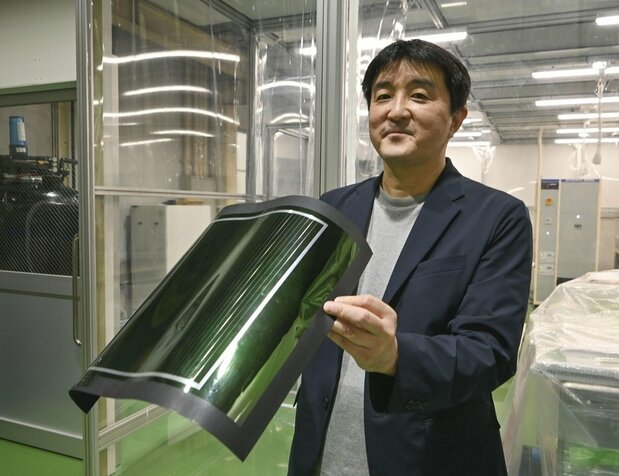 EneCoat Technologies公司社长加藤尚哉手持钙钛矿太阳能电池。2023年9月，京都府久御山町（图片：共同社）