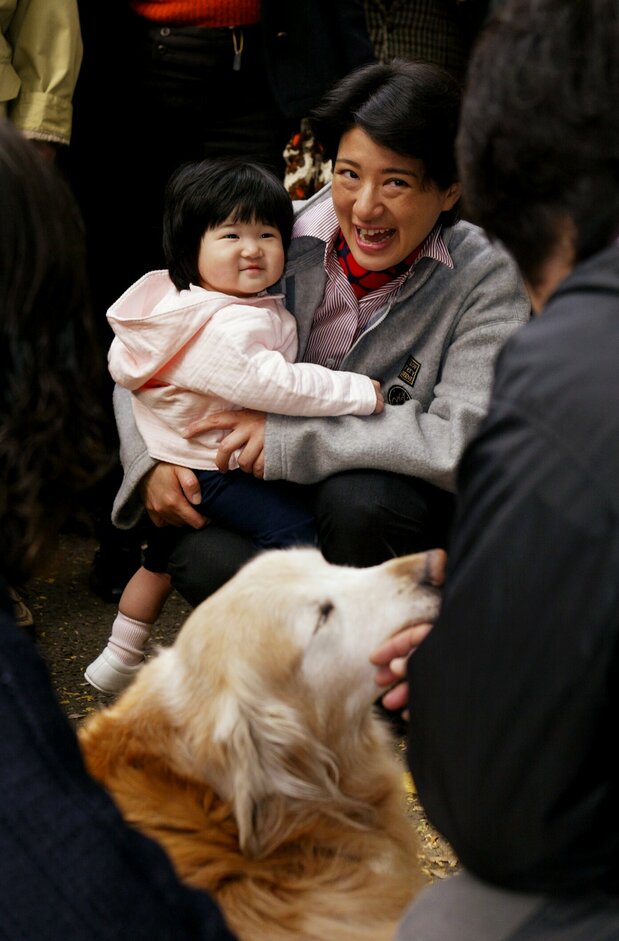 雅子和爱子在神宫外苑散步时遇到一只随主人散步的金毛犬，两人开怀一笑（2002年11月21日，时事社）