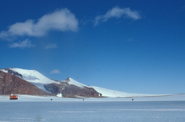 陨石搜索工作现场,3辆雪地摩托与大型雪地车并行,在冰原上搜寻陨石