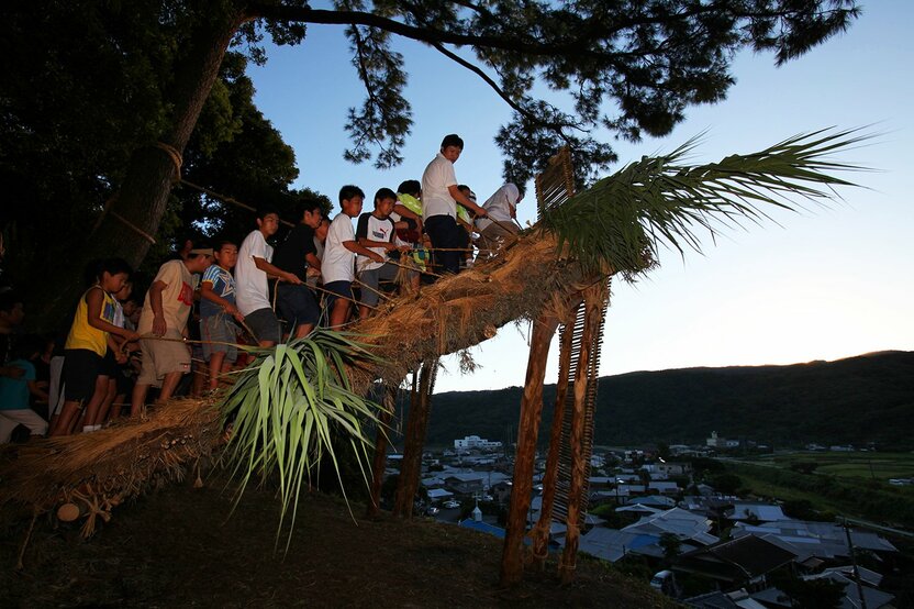 En el distrito de Akina, en la localidad de Tatsugō, donde aún se conservan unas de las pocas zonas de cultivo de arroz que quedan en la isla de Amami-Ōshima, se celebra desde hace siglos el Festival de Akina Arasetsu en el octavo mes del calendario lunar para pedir una buena cosecha. Una de sus tradiciones más emblemáticas es el Shochogama, ritual en el que, al amanecer, los hombres derriban pisoteando los tejados de paja.