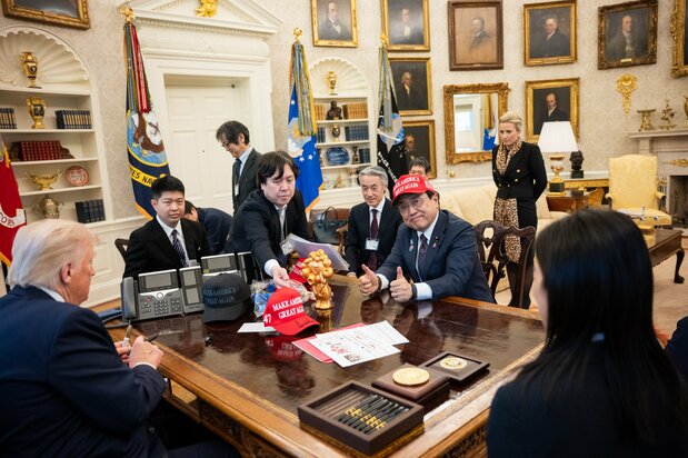 2025年4月16日，时任日本经济再生担当大臣赤泽亮正头戴特朗普总统签名的“MAKE AMERICA GREAT AGAIN（让美国再次伟大）”棒球帽，双手竖起大拇指（ZUMA Press Wire via Reuters Connect）