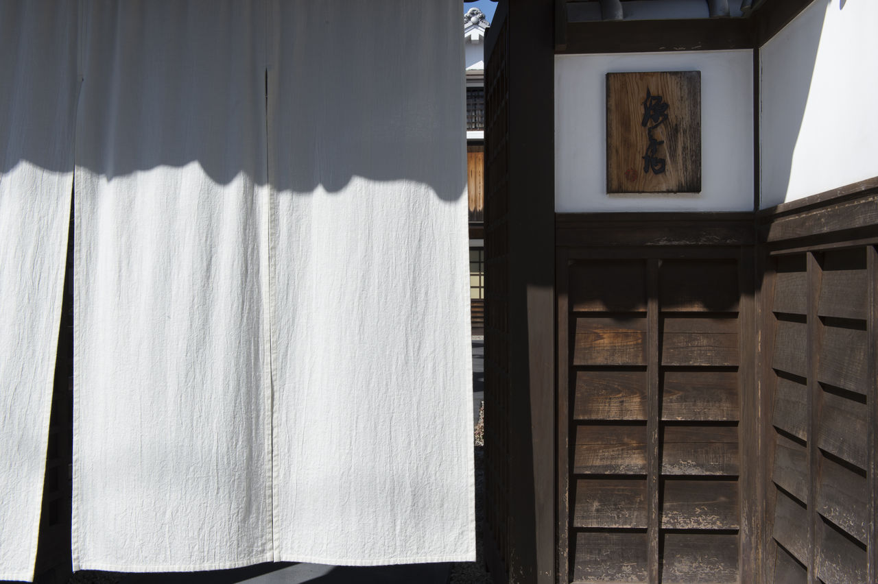 Вход в «Гэмбэй» украшает ослепительно белый норэн. Логотип ресторана справа – это подпись одного из градоначальников эпохи Эдо